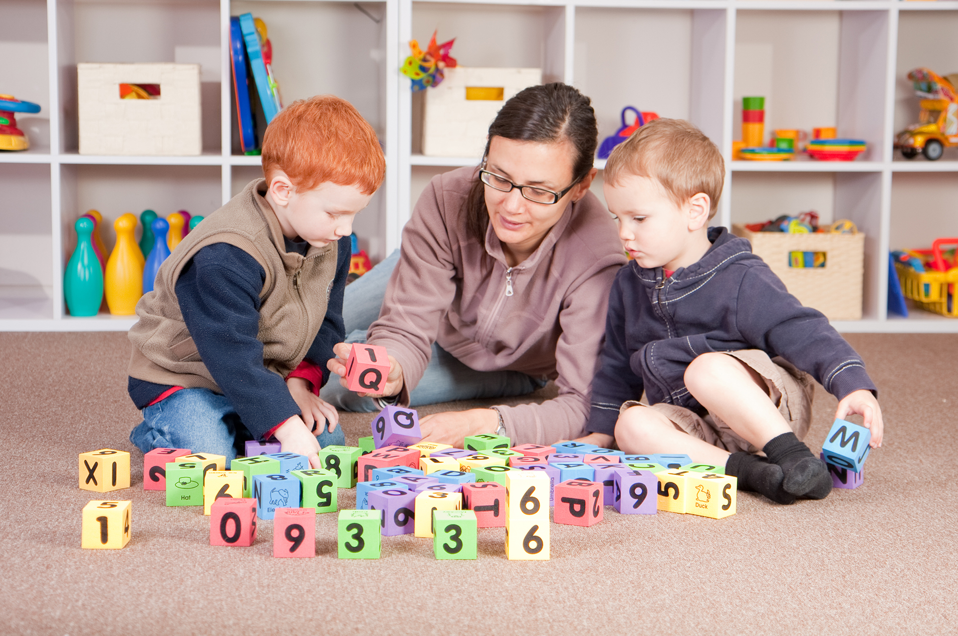 Mother playing blocks games with boys